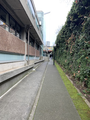 A deserted sunken walkway leading to an anonymous 1960's university building