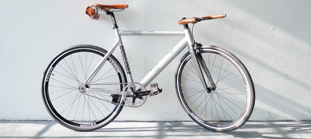 White fixed-gear bicycle leaning on a wall